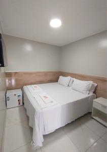 a bedroom with a large white bed in a room at Pousada Chapada do Araripe in Araripina