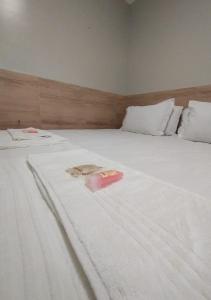 a large white bed with white sheets and pillows at Pousada Chapada do Araripe in Araripina