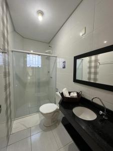 a bathroom with a shower and a toilet and a sink at Divino Residence in Florianópolis