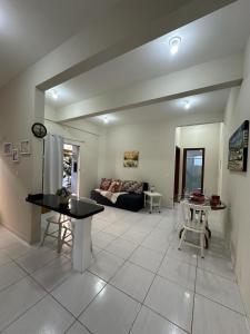 uma sala de estar com uma mesa e um sofá em Divino Residence em Florianópolis
