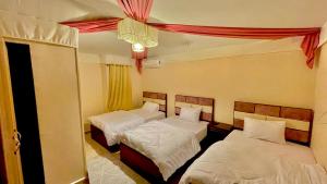1 dormitorio con 2 camas y lámpara de araña en Sami Holiday Inn - pyramids view Rooftop, en El Cairo