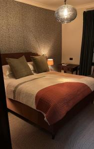 a bedroom with a large bed and a lamp at The Leicester Arms Country Inn in Penshurst