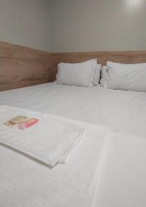 a white bed with white sheets and pillows at Pousada Chapada do Araripe in Araripina