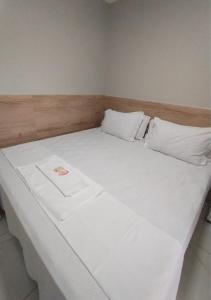 a large white bed with white sheets and pillows at Pousada Chapada do Araripe in Araripina