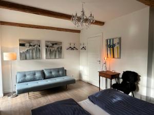 uma sala de estar com um sofá azul e uma mesa em Lindegaardens Bed and Breakfast em Viby