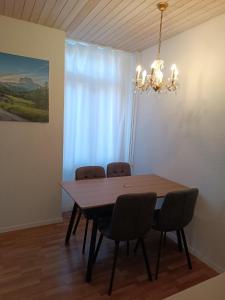 tavolo da pranzo con sedie e lampadario pendente di Apartment Jolie a Interlaken