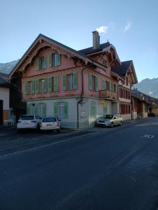 a building with cars parked on the side of a street at Apartment Jolie in Interlaken