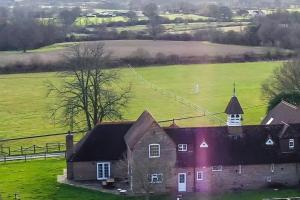 an old house in a field with a church at Stunning Coach House in Sussex in Twineham