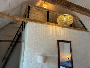 een kamer met een bakstenen muur, een spiegel en verlichting bij Lindegaardens Bed and Breakfast in Viby