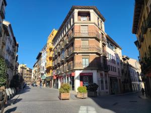 een hoog gebouw aan de kant van een straat bij Acogedor apartamento para dos en el centro in Huesca