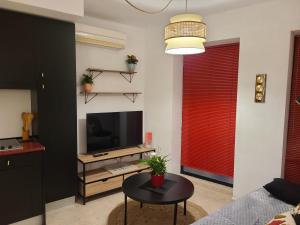 a living room with a television and a table at Acogedor apartamento para dos en el centro in Huesca