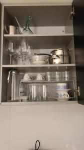 a kitchen cabinet filled with lots of pans and dishes at Acogedor apartamento para dos en el centro in Huesca