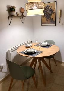 een eettafel met 2 stoelen en een tafel met stoelen bij Acogedor apartamento para dos en el centro in Huesca