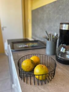una cesta de fruta en la encimera de la cocina en Appartement tout confort, en Sainte-Anne