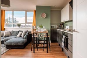 eine Küche und ein Wohnzimmer mit einem Tisch und einer Couch in der Unterkunft Newley Decorated Central Maidstone Flat, Sleeps 4 in Maidstone + 25 Fotos