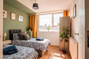 a bedroom with two beds and a window at Newley Decorated Central Maidstone Flat, Sleeps 4 in Maidstone