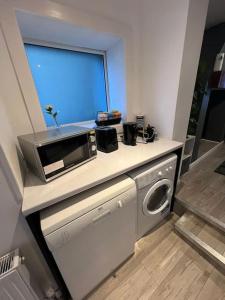 een keuken met een magnetron en een wasmachine bij Haven - Beautiful 3 Bedroom house in Ballynahinch