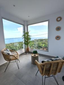 sala de estar con 2 sillas y ventanas grandes en La Palma Luxury Heritage en Las Ledas