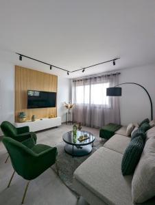 sala de estar con sofá, sillas y TV en La Palma Luxury Heritage, en Las Ledas