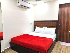1 dormitorio con 1 cama con manta roja en Hotel comfort inn en Calangute