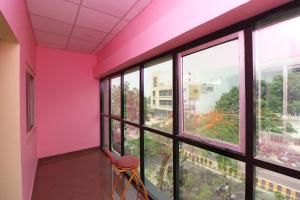 a room with pink walls and windows and a stool at OYO SHRI RAM Homestay in Kāthgodām