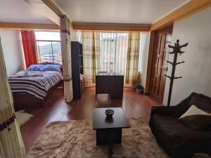 a living room with a couch and a bed at ESTANCIA COMODA Sicuani in Sicuani