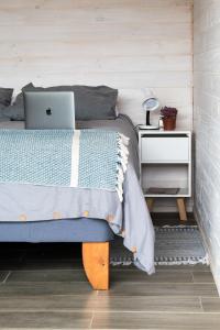 um quarto com uma cama com um computador portátil em VIENTO BRAVO em Pichilemu