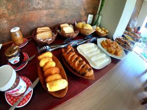 a table topped with different types of bread and pastries at Pousada Natureza Viva in Itacaré