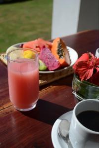 un tavolo con un bicchiere di succo e un piatto di cibo di Pousada Natureza Viva a Itacaré