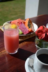 a table with a glass of juice and a plate of food at Pousada Natureza Viva in Itacaré