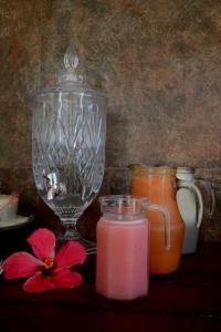 a glass vase and a pink drink and a flower at Pousada Natureza Viva in Itacaré