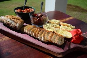 a wooden table with a tray of bread and fruit at Pousada Natureza Viva in Itacaré
