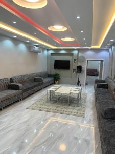 استراحة زهرة الاماكن 2 في جدة: غرفة معيشة مع كنب وتلفزيون وطاولة
