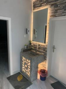 La salle de bains est pourvue d'un lavabo en pierre et d'un miroir. dans l'établissement استراحة زهرة الاماكن 2, à Djeddah