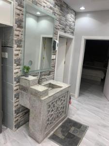 a bathroom with a stone sink and a mirror at استراحة زهرة الاماكن 2 in Jeddah