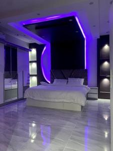 - une chambre avec un grand lit et un éclairage violet dans l'établissement استراحة زهرة الاماكن 2, à Djeddah