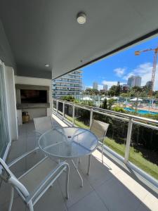 a glass table and chairs on a balcony with a view at Apartamento in Punta del Este
