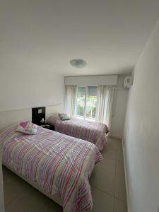 three beds in a room with a window at Apartamento in Punta del Este