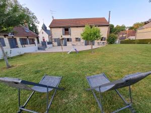 duas cadeiras sentadas na relva num quintal em Chambres d'hôtes Le Clos Poli em Montigny-les-Monts