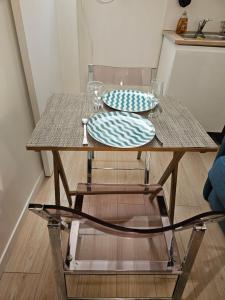 a wooden table with two plates on top of it at Studette Rémilly à Versailles in Versailles