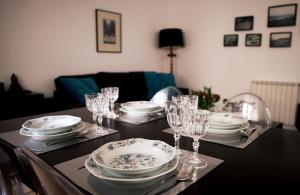 a table with plates and wine glasses on it at Triplex with Garage - Praça das Flores in Lisbon