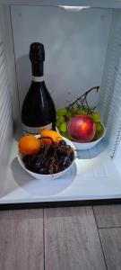 ローマにある247 ラグジュアリー ルームズ トラステヴェレの冷蔵庫にフルーツプレートとボトル1本