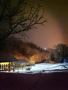 een sneeuwbedekte tuin 's nachts met een hek bij Brvnare Duguljac Fruška Gora in Bukovac
