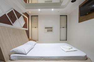 um pequeno quarto com uma cama e uma televisão em Motel Disco Verde Congonhas 1 em São Paulo