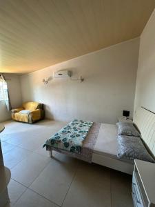 een slaapkamer met een bed en een bank in een kamer bij Casa Rosemary in Lauro de Freitas