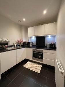 a kitchen with white cabinets and a sink at Peaceful shared flat 30mins Central London in Colindale