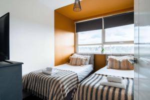 dwa łóżka w pokoju z oknem w obiekcie Central Maidstone Contractor Flat w mieście Maidstone