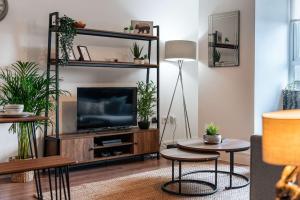 a living room with a tv and some plants at Central Maidstone Contractor Flat in Maidstone