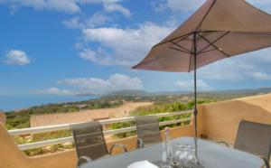 a table with an umbrella on a balcony at Terrasse du Levant in Bocca del Oro