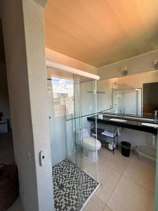 a bathroom with a toilet and a glass shower at Casa Rosemary in Lauro de Freitas